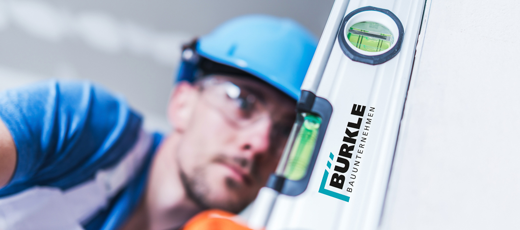 BUERKLE BAUUNTERNEHMEN Mann mit Wasserwaage BUERKLE BAUUNTERNEHMEN Mann mit Wasserwaage